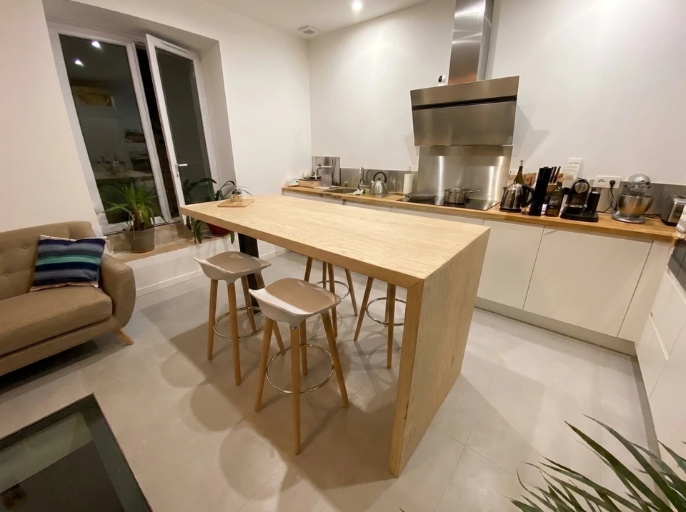 Escalier en bois massif à limons courbes design contemporain, sans contremarches, fixé à un poteau porteur en chêne foncé
